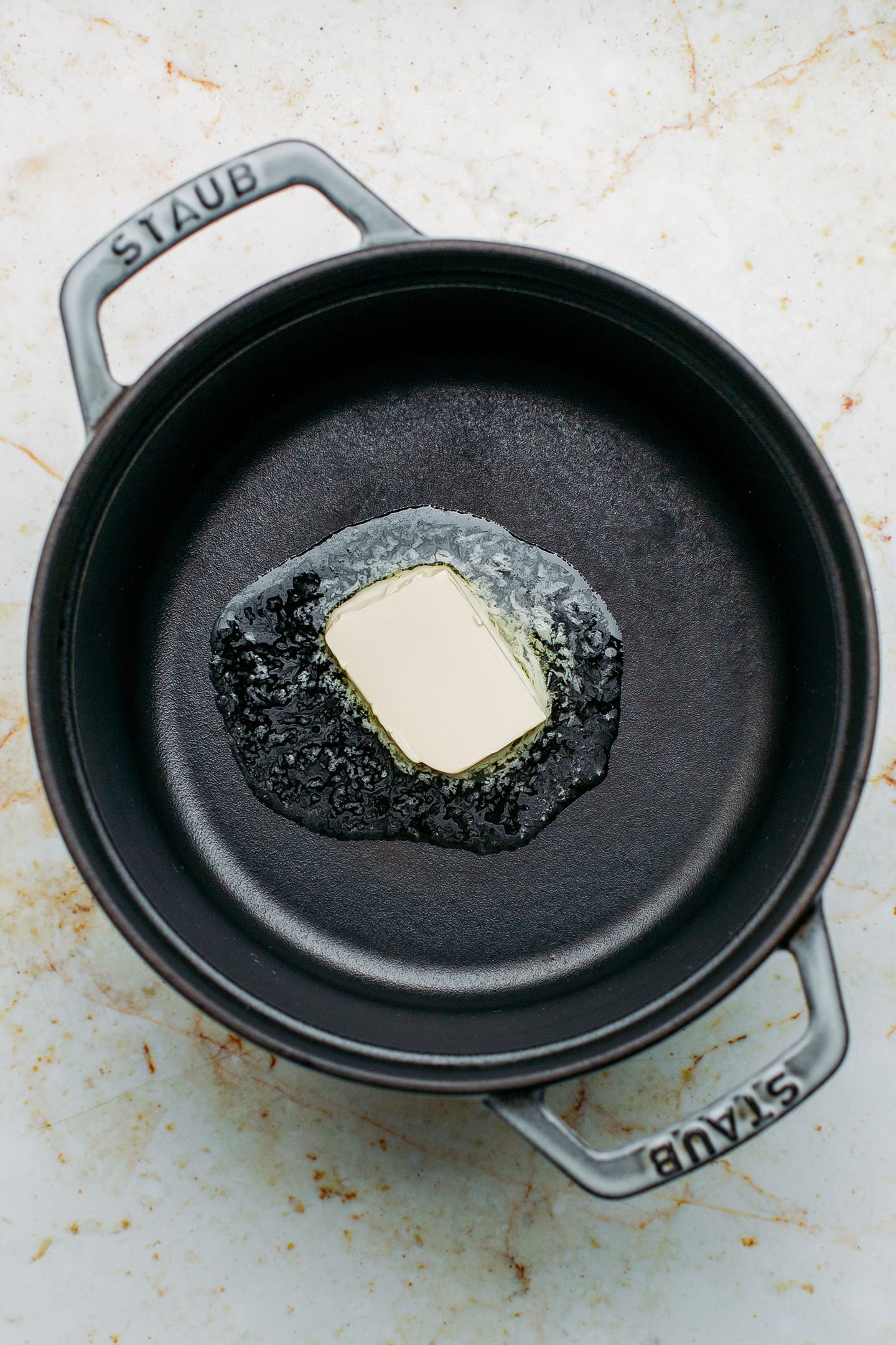 Cube of butter melting in a pot.