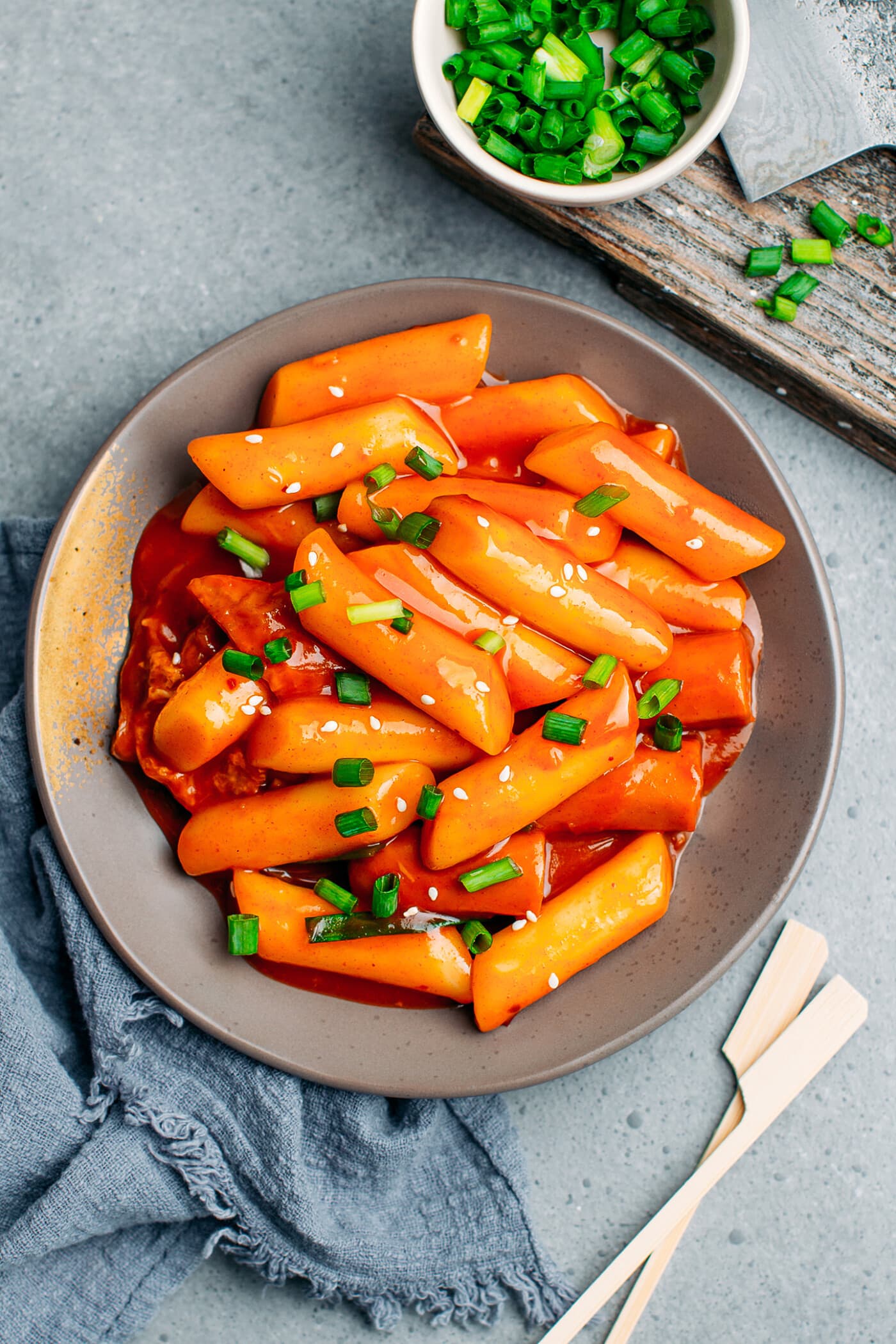 Spicy Korean Tteokbokki cakes in a bowl with chopsticks.