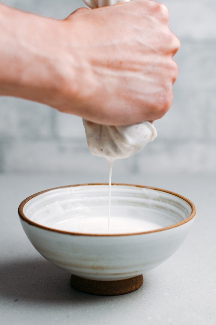 Straining almonds to make almond milk.