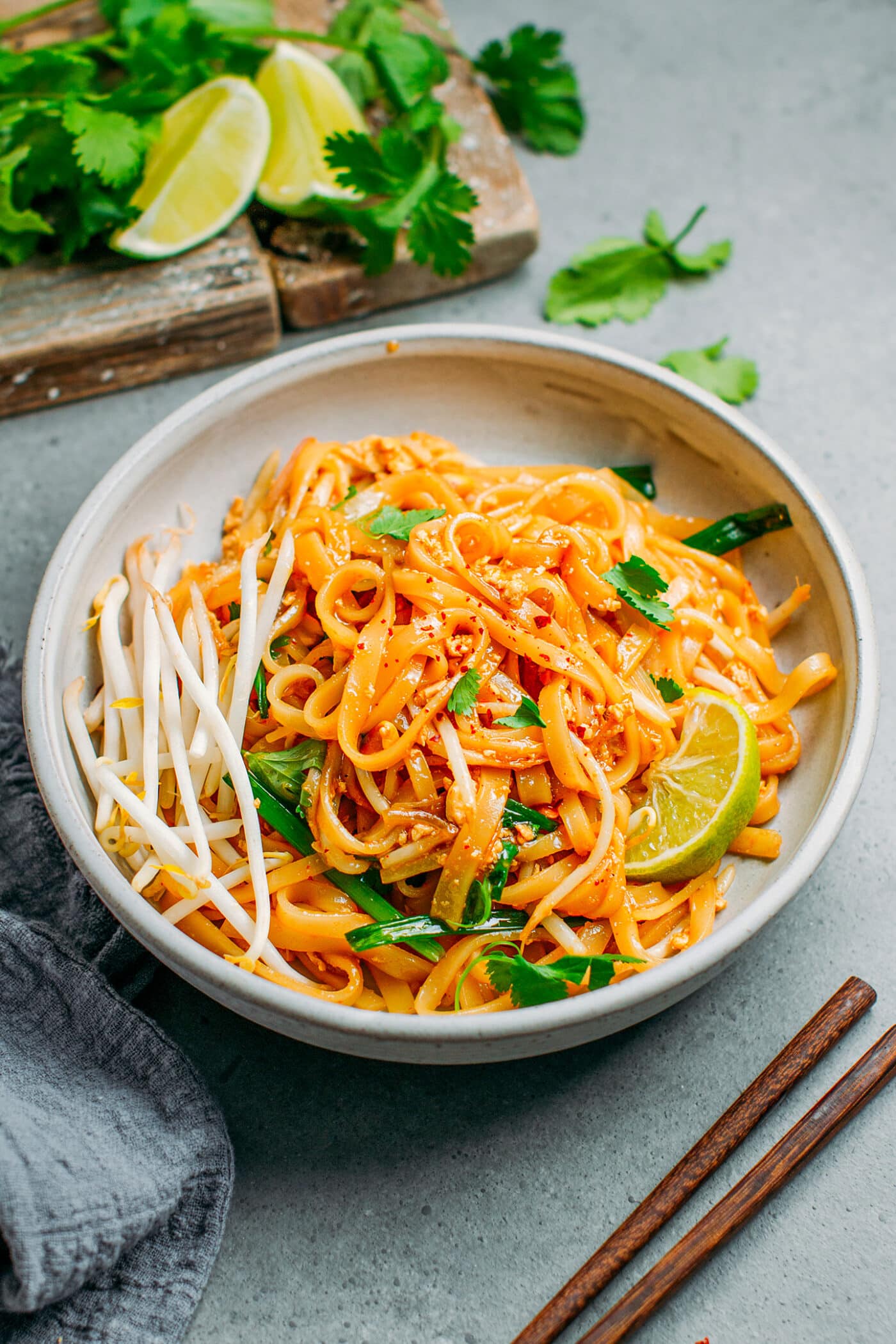 Vegan Pad Thai in a bowl with green onions, bean sprouts, and lime.