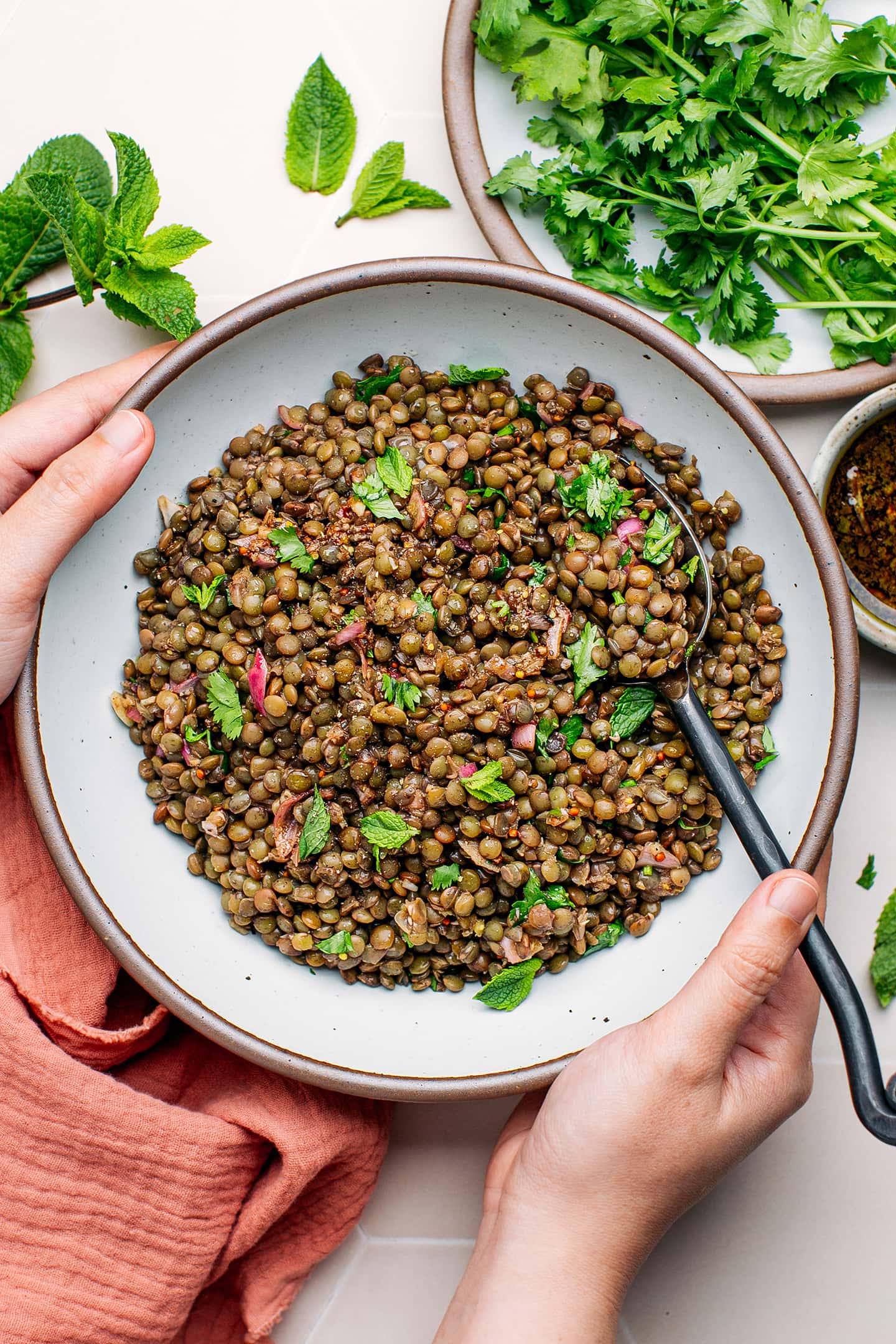 Holding a bowl of green lentil salad.