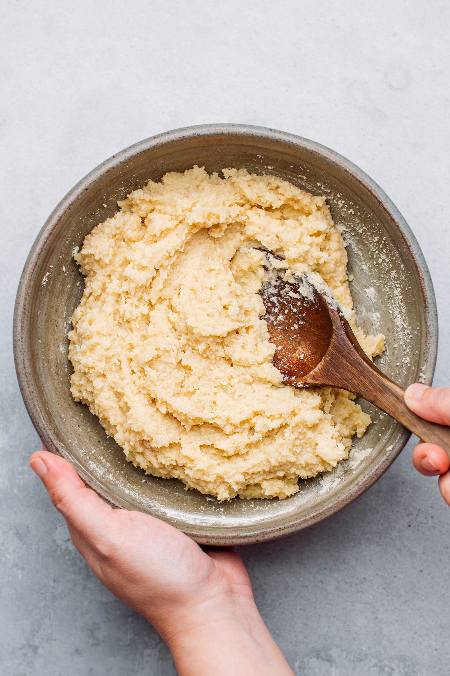 Mixing almond paste in a mixing bowl.