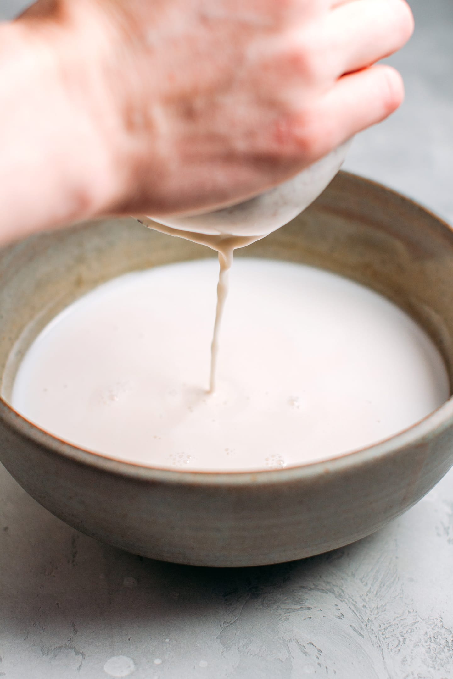 Straining hazelnut milk through a nut milk bag.