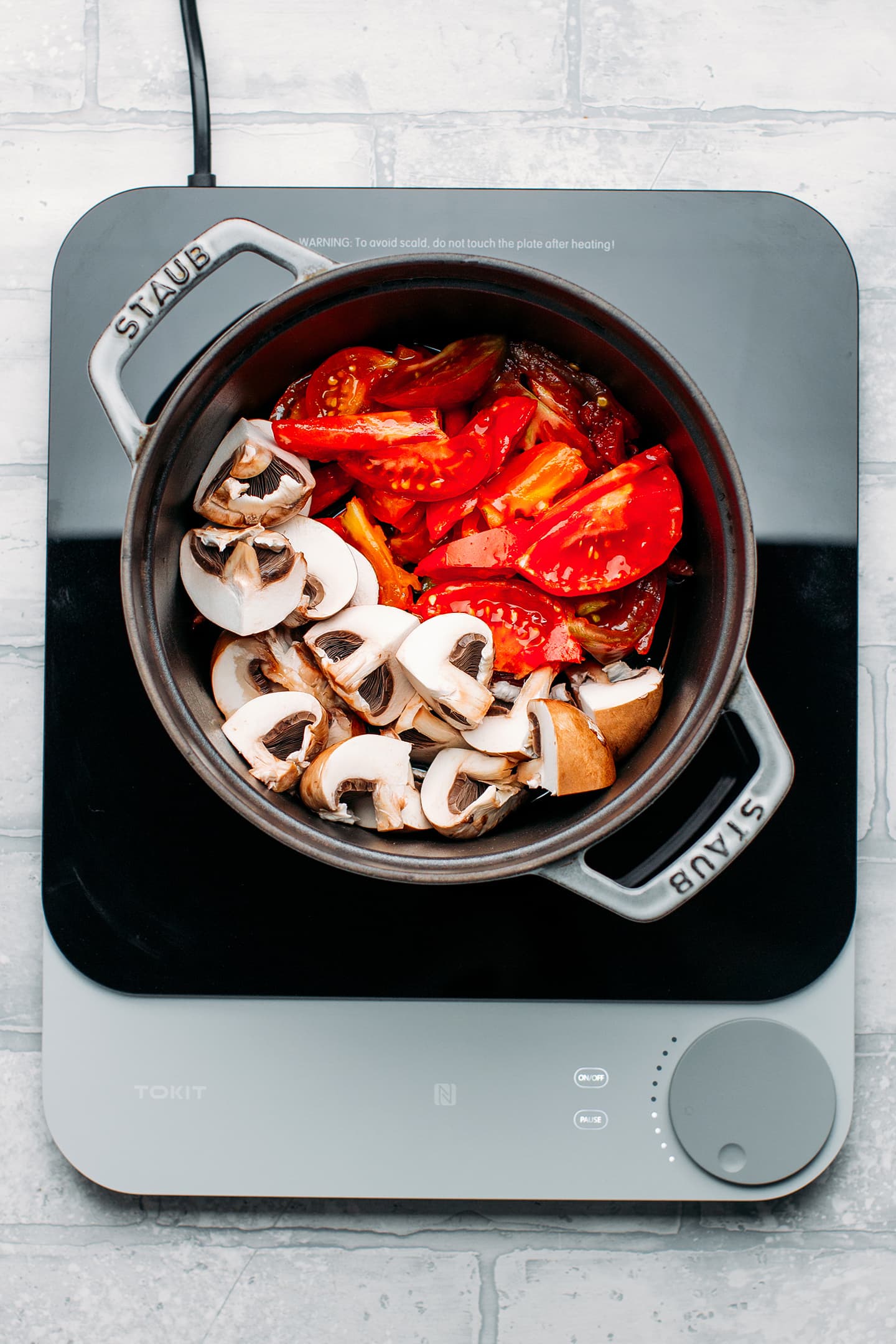 Mushrooms and tomatoes in a pot.