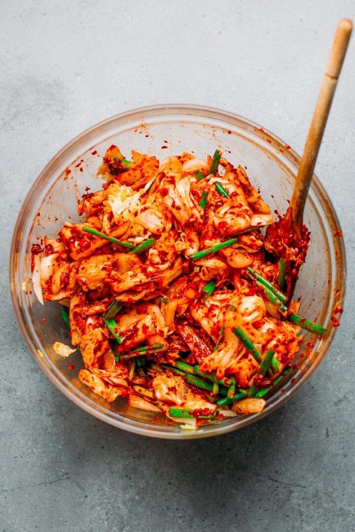 Coating Napa cabbage with chili paste to make kimchi.