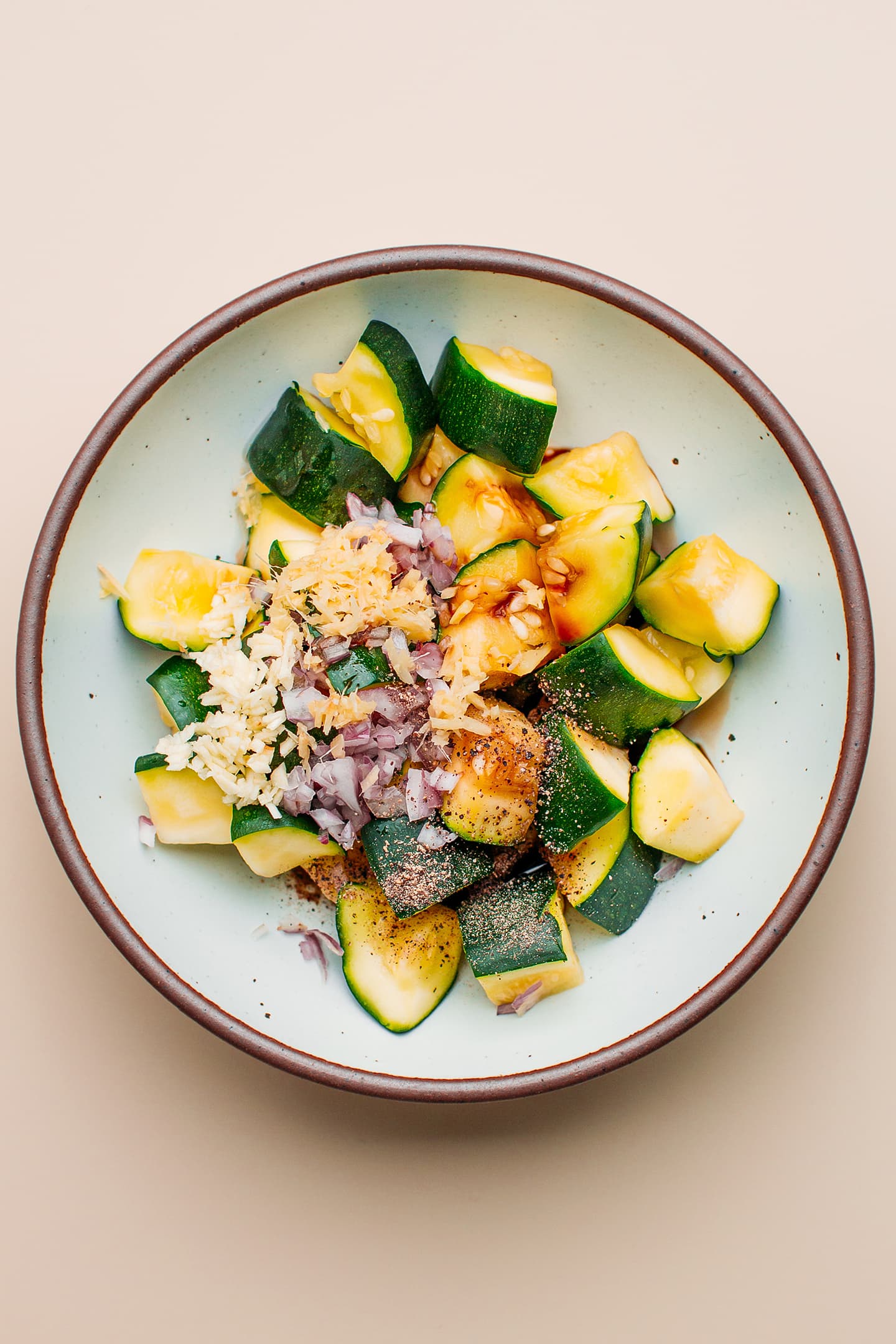 Diced zucchini, ginger, garlic, and shallots in a bowl.