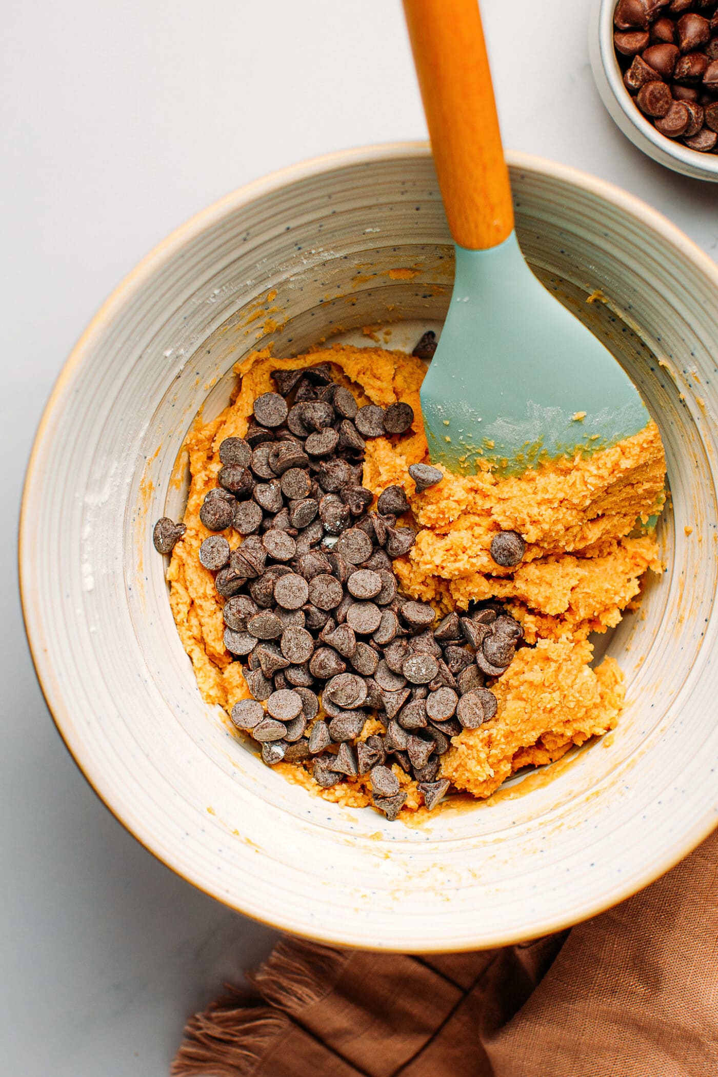 Cookie dough with dark chocolate chips in a bowl.