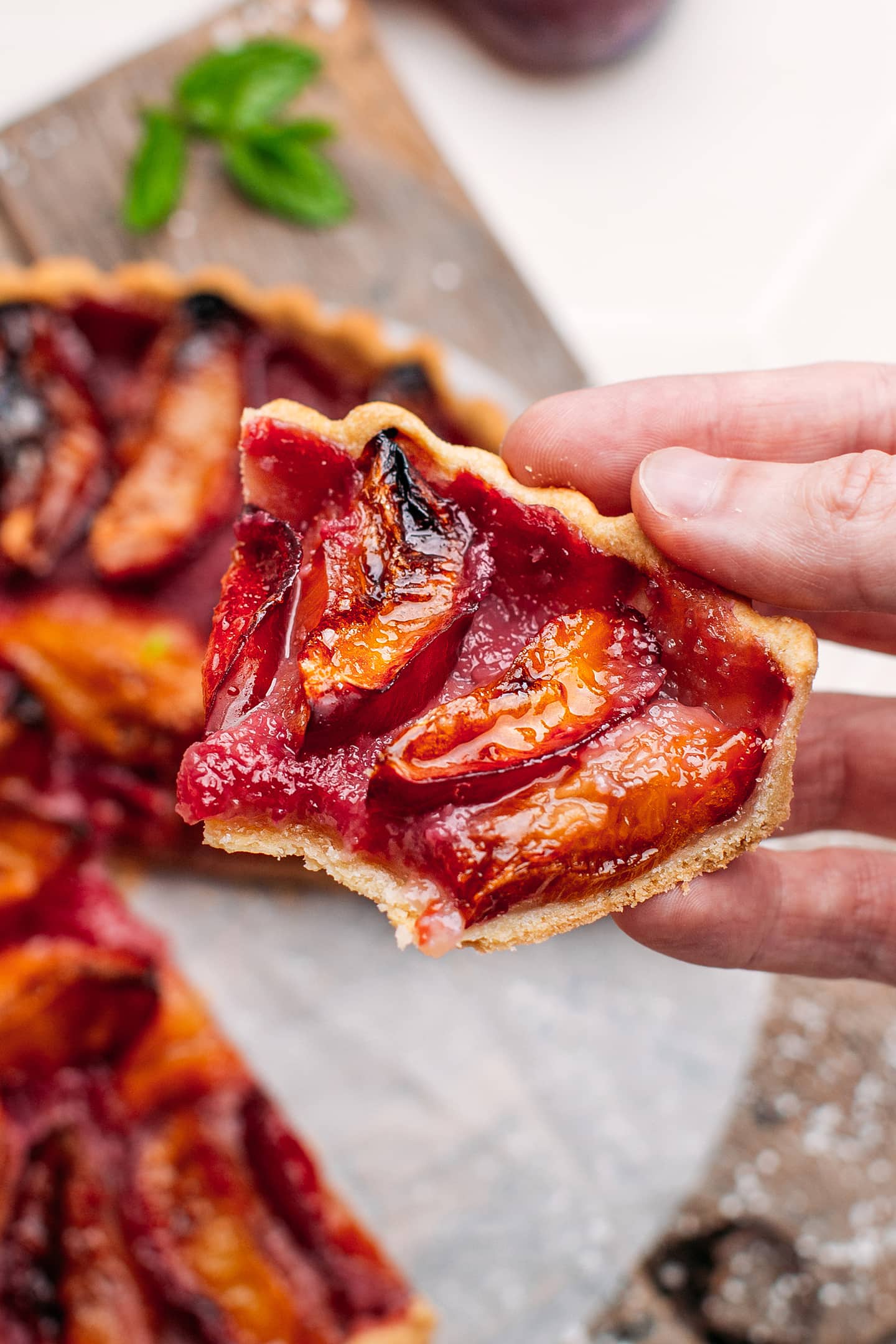 Holding a slice of plum tart.