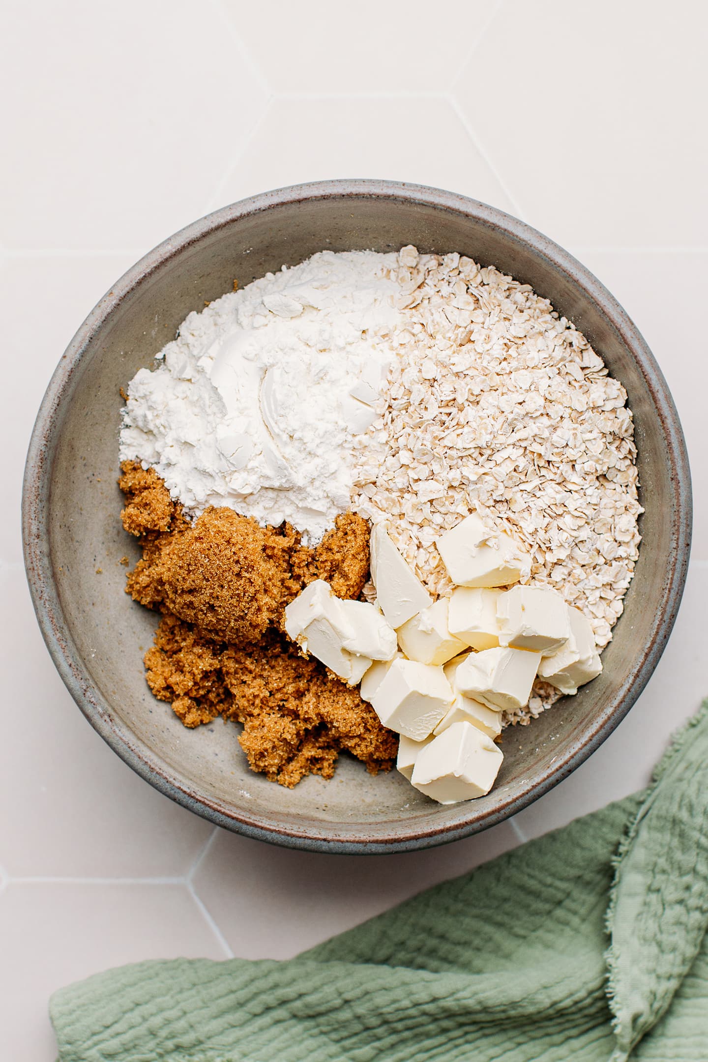 Flour, brown sugar, oats, and butter in a mixing bowl.