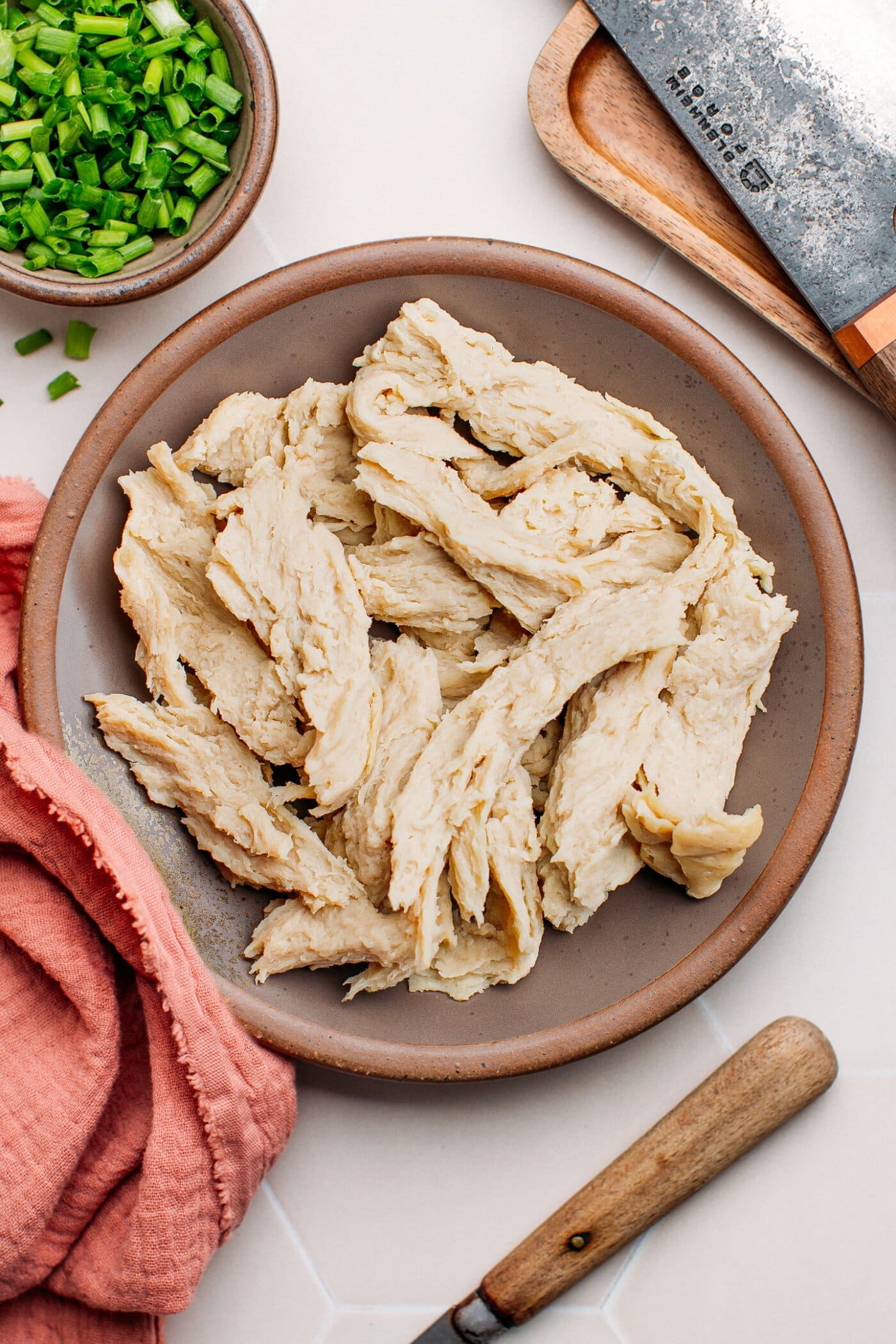 Vegan shredded chicken on a wooden board.