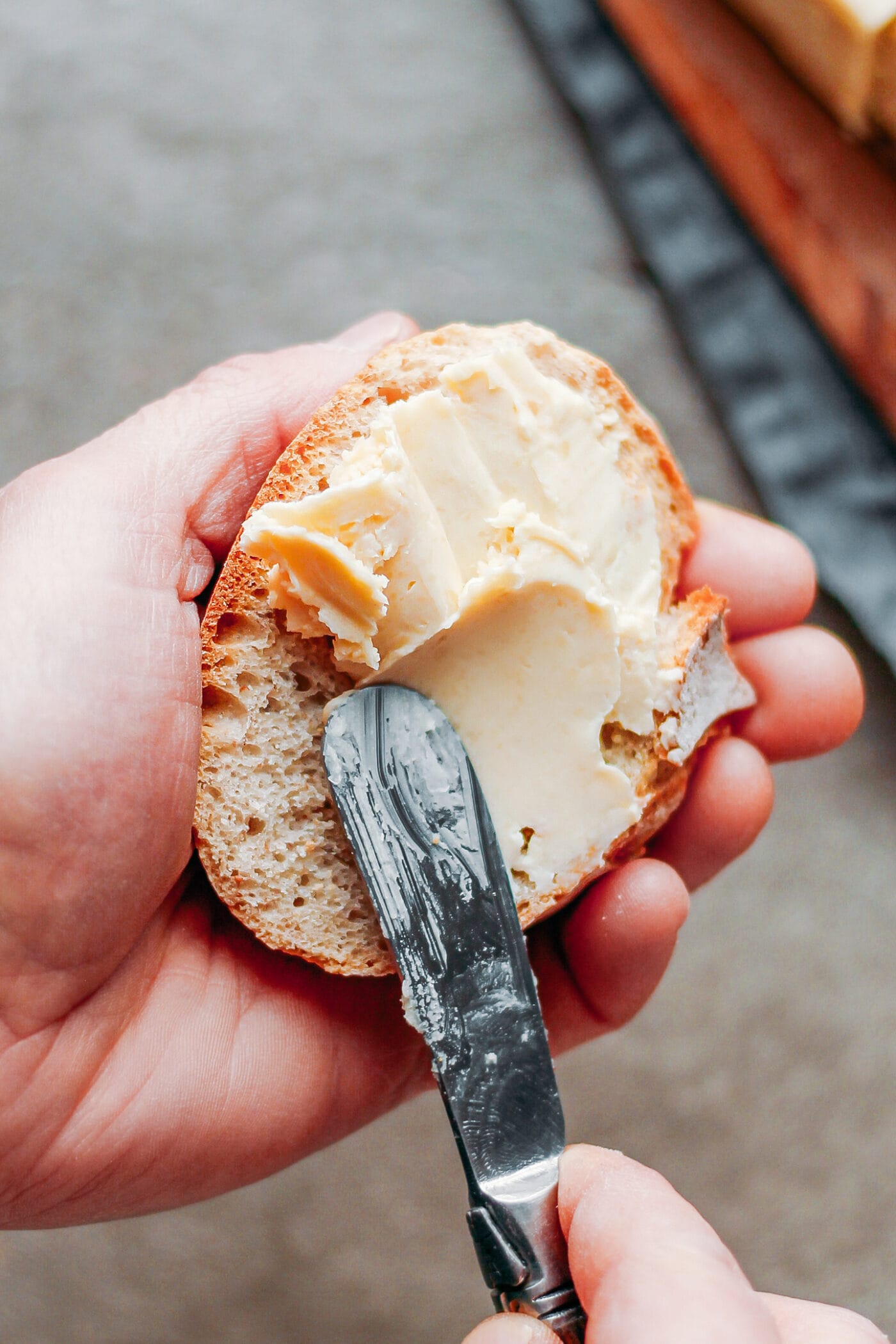 Spreading vegan butter on a slice of bread.