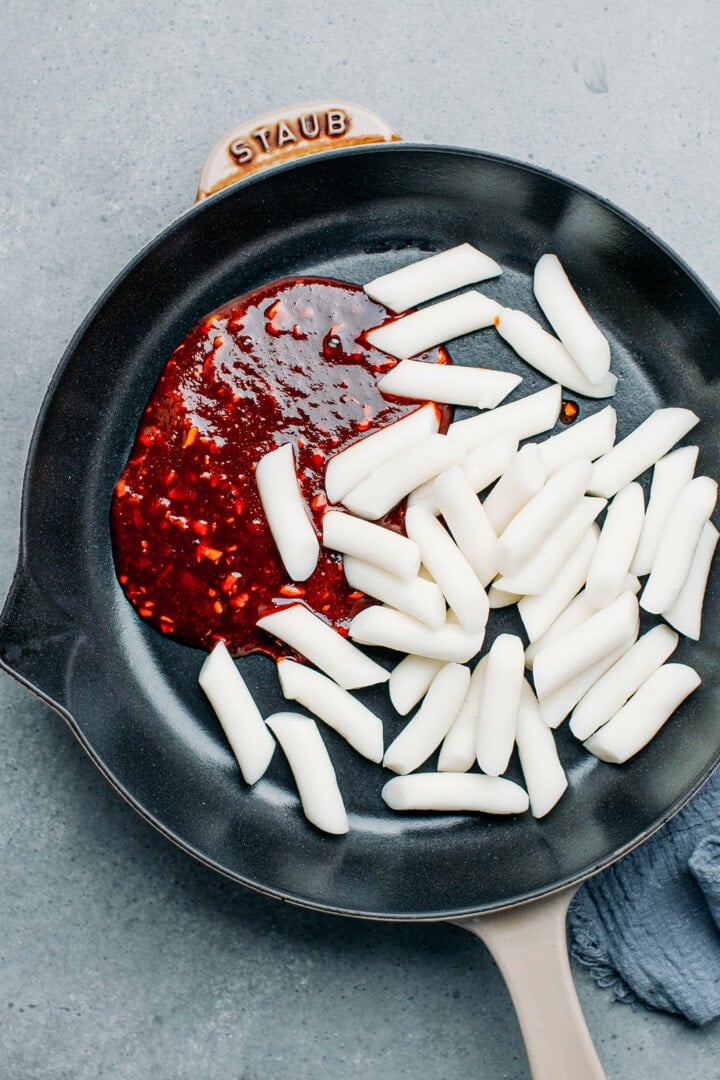 Rice cake and tteokbokki sauce in a pan.