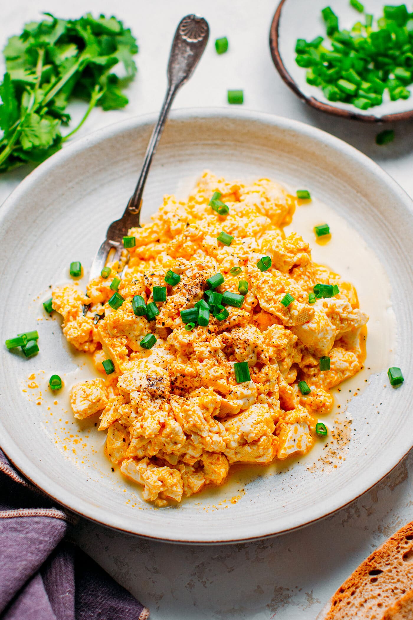 Vegan tofu scrambled topped with black pepper and green onions.