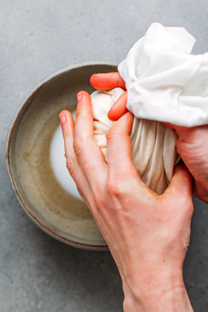 Draining tofu in a nut milk bag.