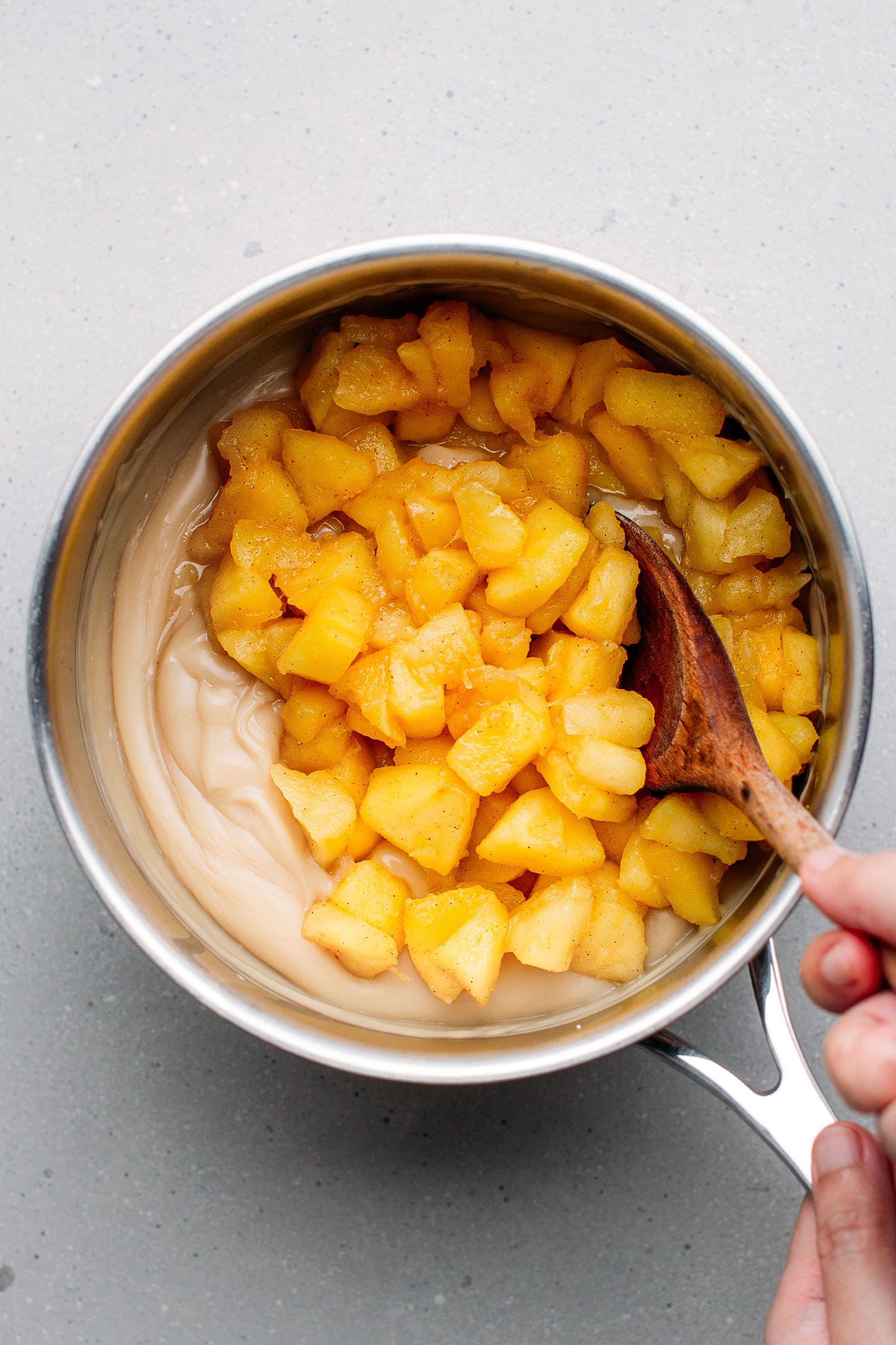 Stirring sautéed caramel into vanilla cream.