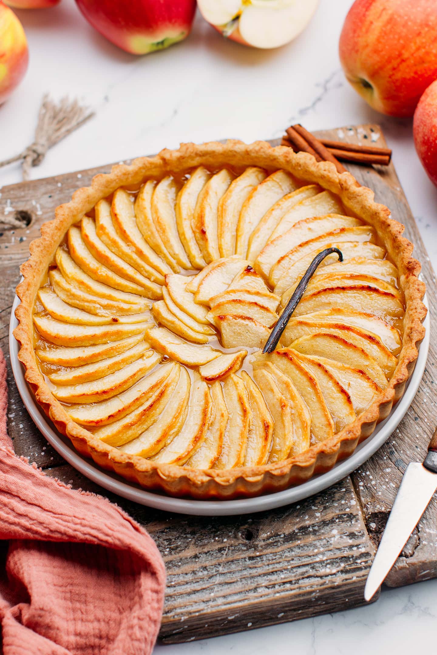 Whole apple tart on a wooden board.