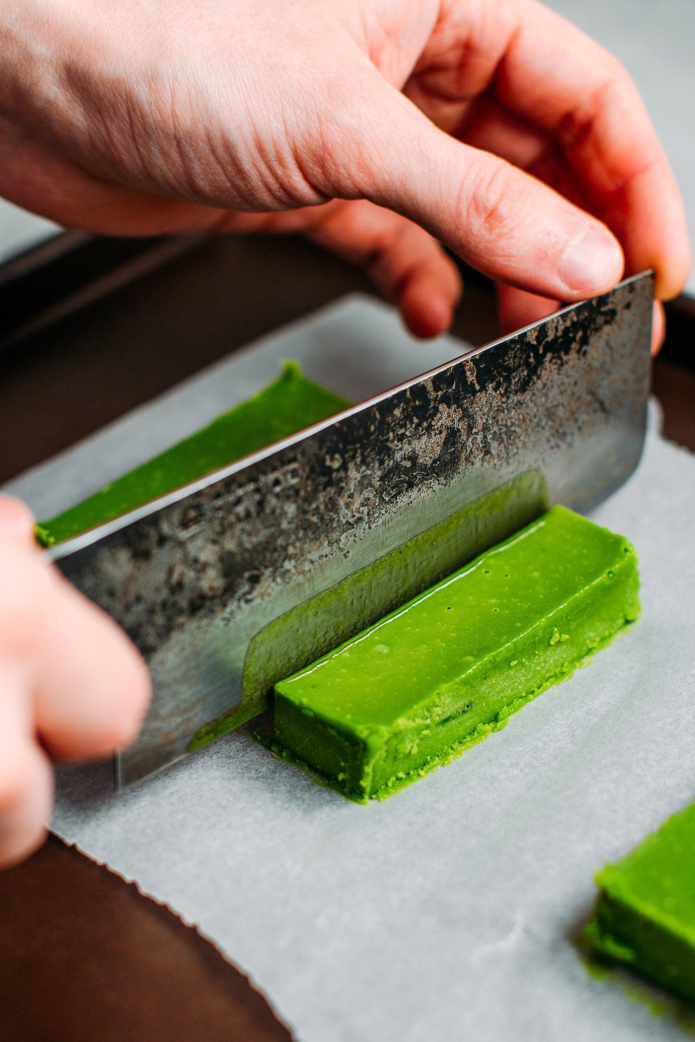 Cutting matcha white chocolate ganache into squares.