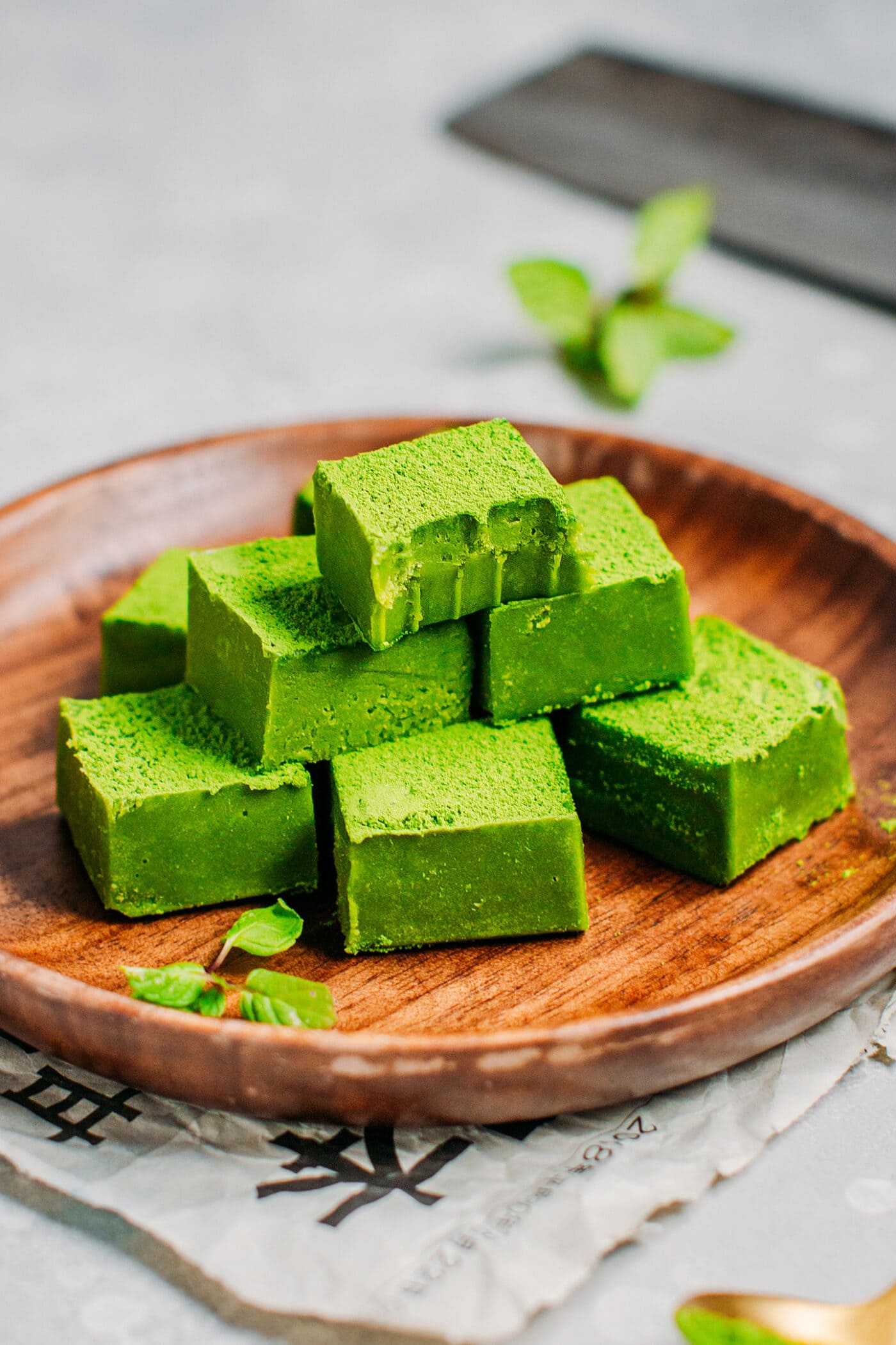 Matcha nama chocolates on a wooden plate.