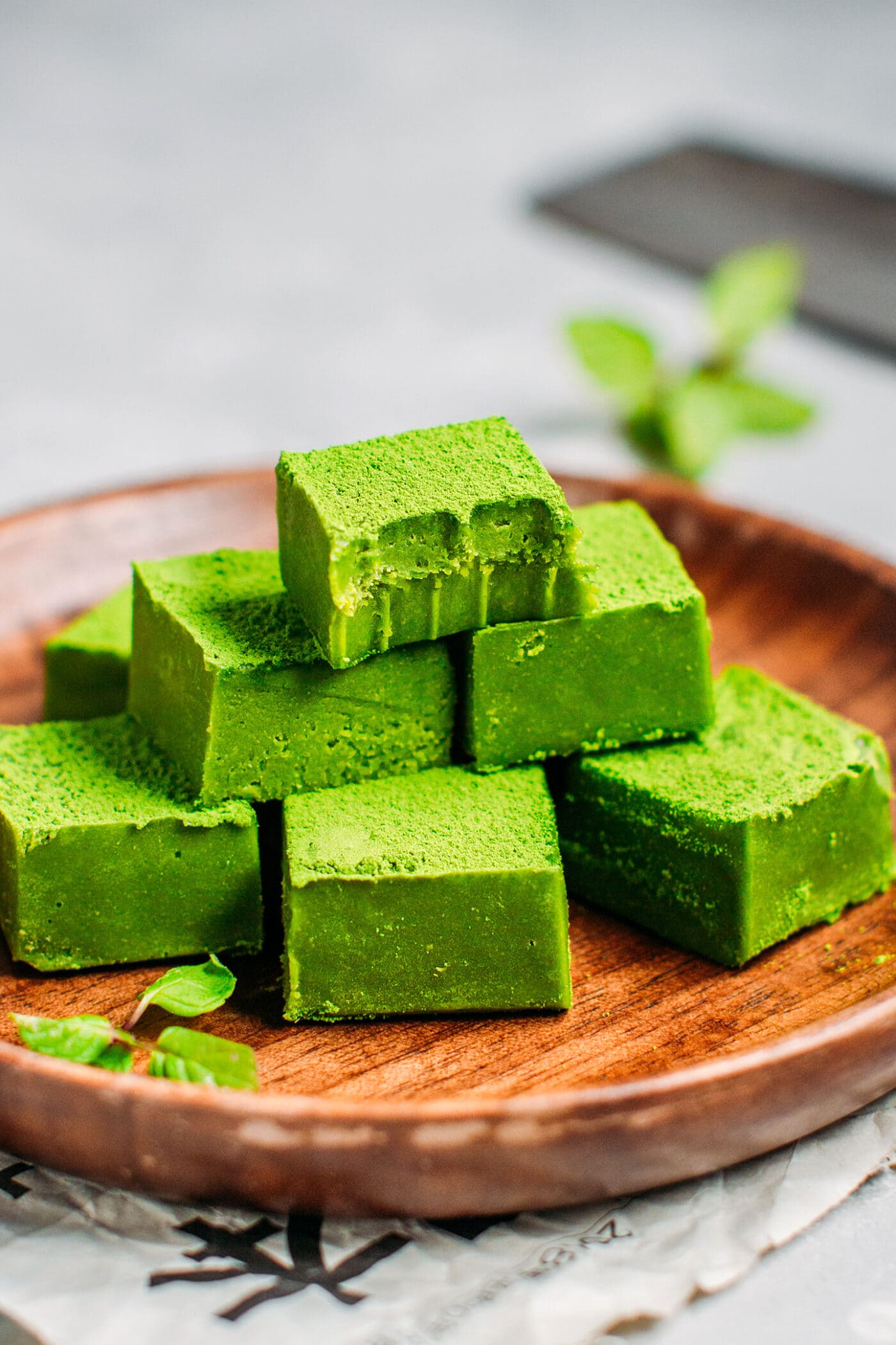 Matcha nama chocolates on a wooden plate.