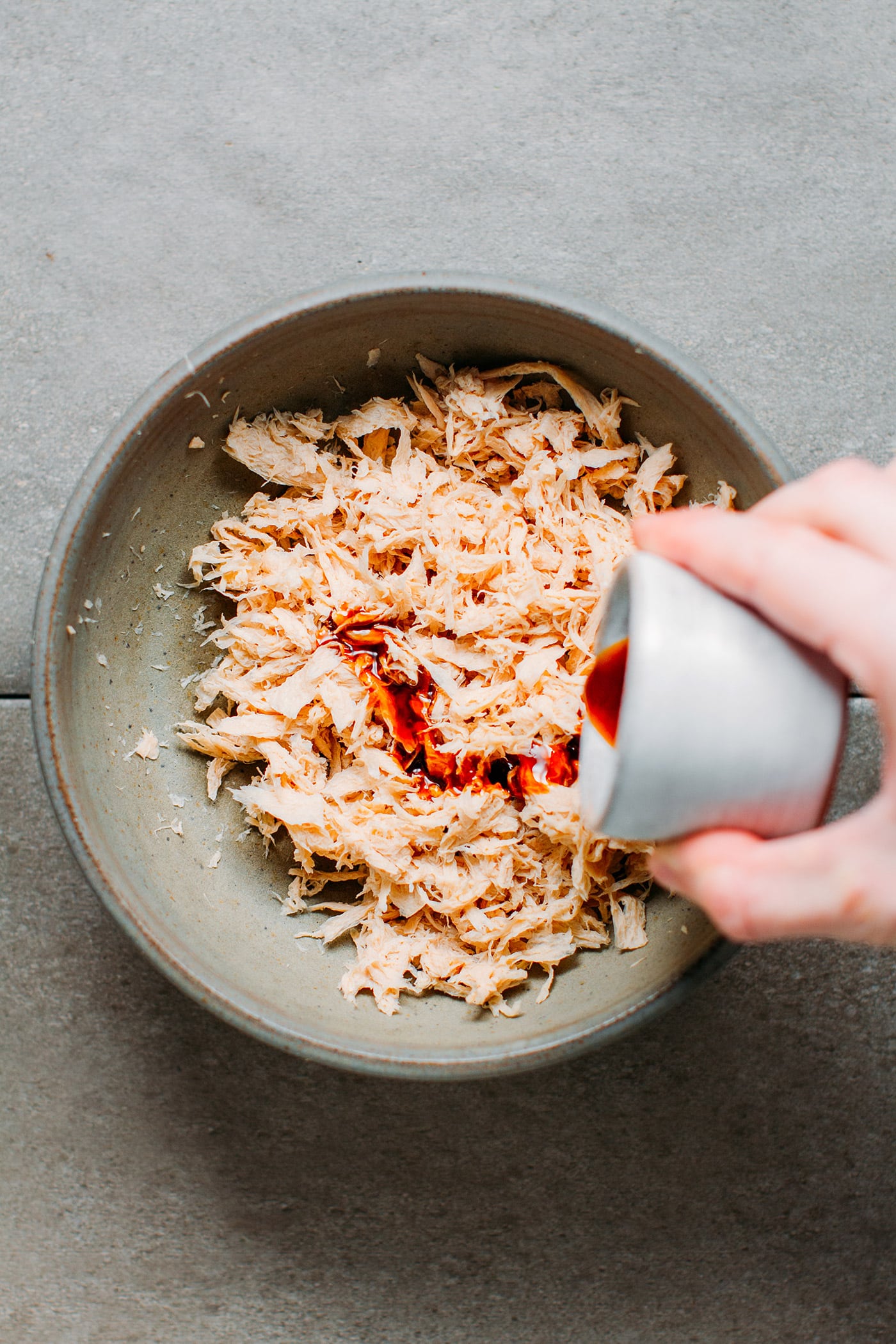 Pouring sauce over shredded tvp.