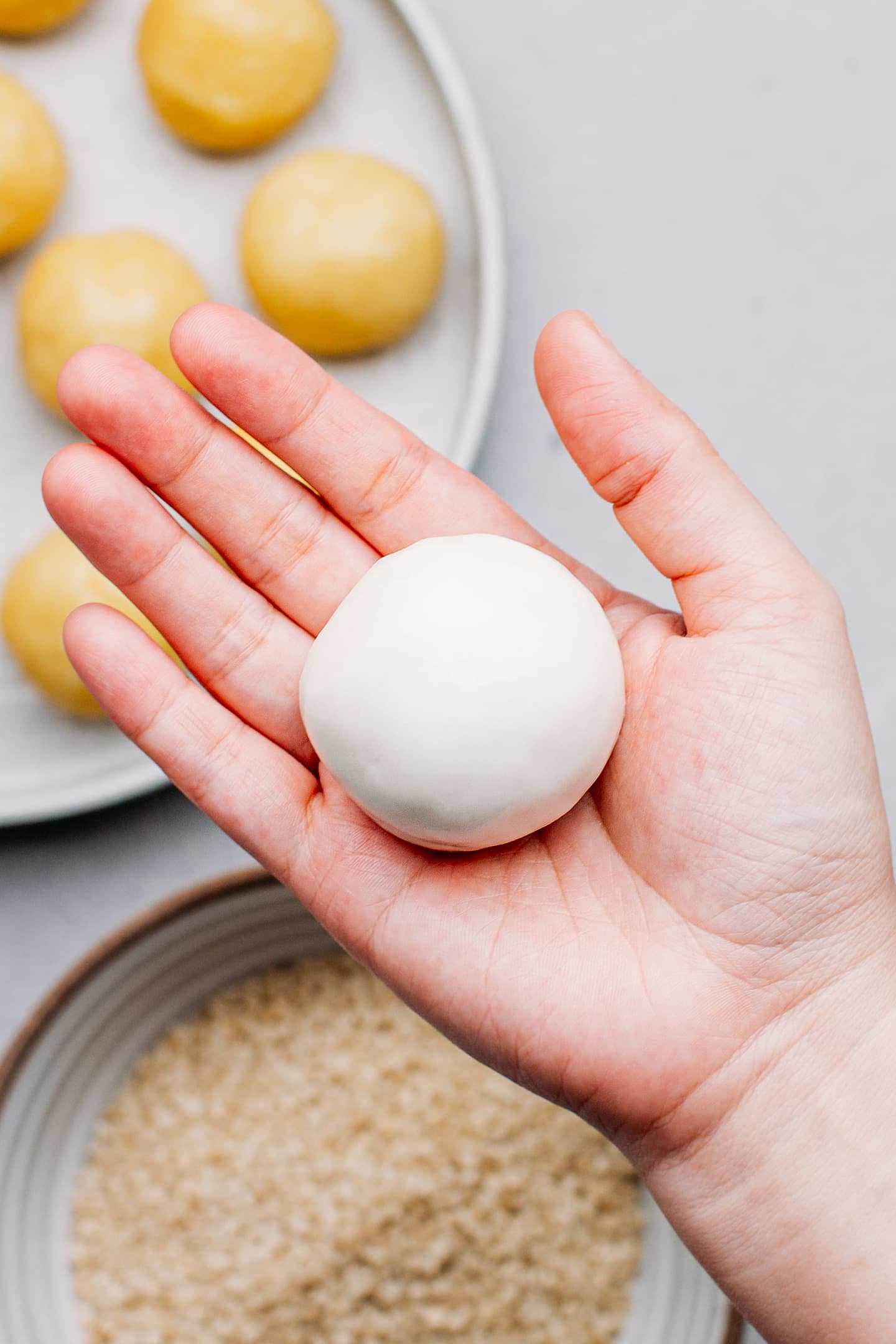 Holding a wrapped sesame ball.