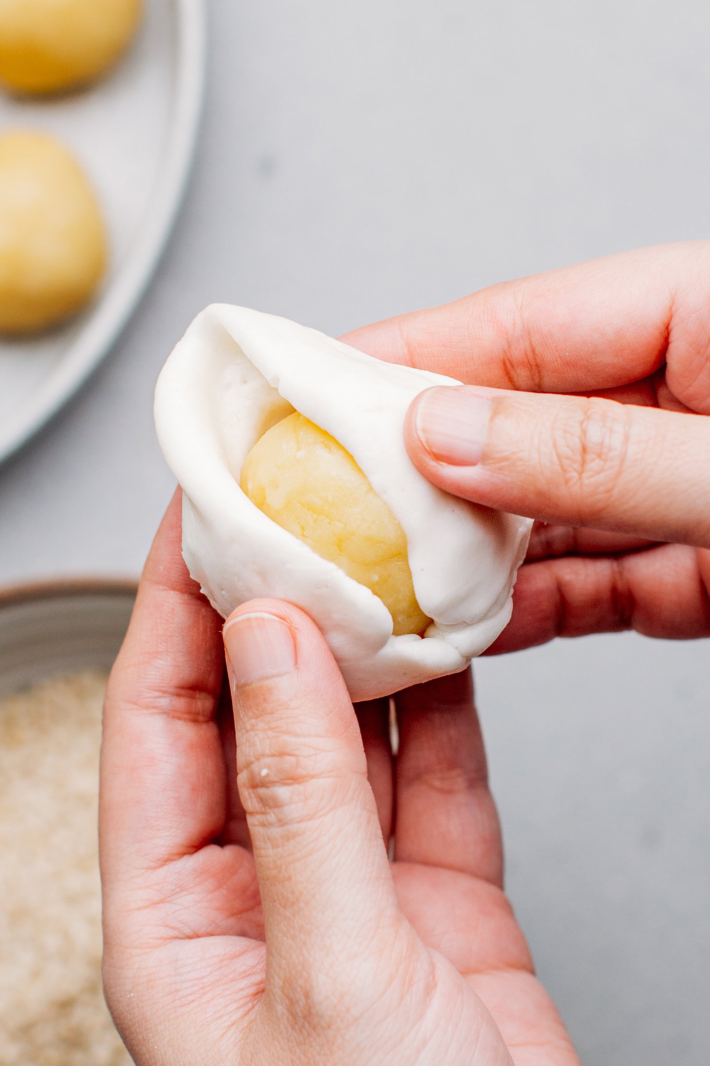 Wrapping mung bean filling with a wrapper.