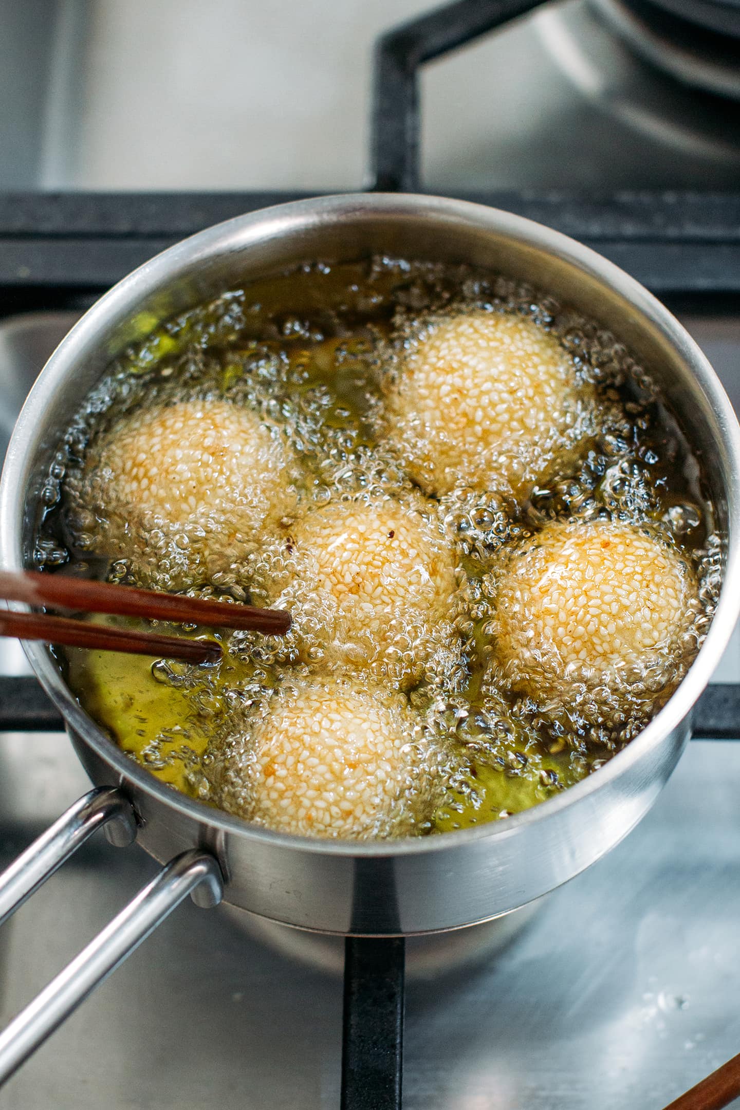 Frying sesame balls in a saucepan.